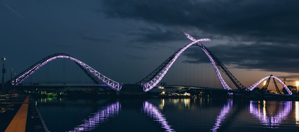The Matagarup Bridge lit up in purple at night.