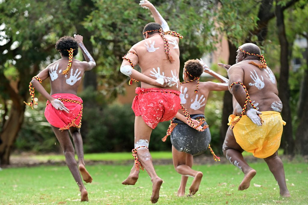 Group of Aboriginal Australians people dancing traditional dance during Australia Day celebrations
