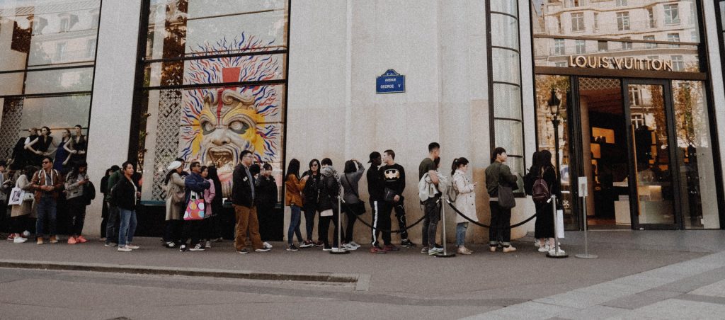 Customers lining up outside a Louis Vuitton Store