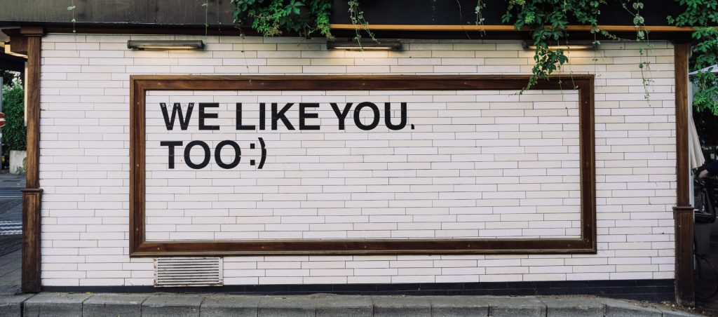 Sign displaying a social impact statement 'We like you, too :)'