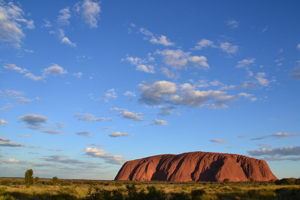 Landscape image of Uluru on a partly cloudy day